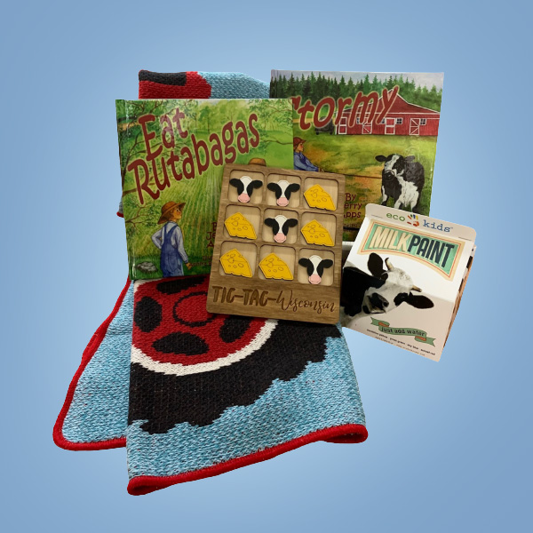 Prize Pack 1 for Member Month 2023. 2 kids books: Eat Rutagbagas and Stormy by Jerry Apps, a tic tac Wisconsin board: cow heads and cheese make up the game pieces, a milk paint kit and a tractor kids blanket.